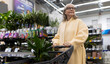 © Ivan Traimak - Senior woman pushing shopping cart with houseplant in a retail store
