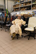 © Ivan Traimak - Woman sitting in an office chair, shopping for new furniture in a large warehouse store