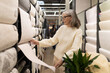 © Ivan Traimak - Mature woman shopping for wallpaper, renovating home interior design