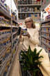 © Ivan Traimak - Woman reading label on paint can inside a hardware store, home improvement concept