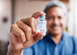© peopleimages.com - Covid, vaccine and hand with old man for medical, wellness or medicine for illness. Disease, healthcare and senior person with drugs bottle for virus, safety or risk to immune system and treatment