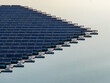 © AmazingAerialAgency - Aerial view of floating photovoltaic system with rows of solar panels on white floats over calm water during golden hour Bensheim, Hessen, Germany.