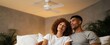 © ckybe - The ceiling fan twirls like a gentle dancer refreshing a couple in their cozy bedroom.