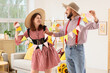 © Pixel-Shot - Young couple with flags celebrating Festa Junina (June Festival) at home