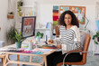 © Pixel-Shot - Female African-American interior designer with color palettes at table in office