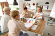 © Pixel-Shot - Team of graphic designers working with color palettes at table in office