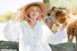 © Parilov - Travel trip in amusement park Nha trang, Vietnam. Young caucasian female feeding giraffe while wearing traditional hat at zoo