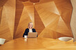 © baranq - Businesswoman working on laptop at modern wooden desk