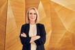 © baranq - Confident businesswoman with arms crossed smiling in modern office