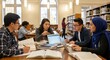 © Bunlong - Students studying in a library with books, laptops, and a blue scarf.