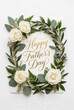© AlexCobalt - Oval olive and eucalyptus wreath with white roses and gold 'happy father's day' script for father's day card design and floral greeting background