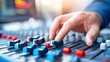 © Maina - Hand Adjusts Sliders on Professional Audio Mixing Console in Studio Setting
