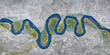 © AmazingAerialAgency - Aerial view of the meandering Owens River flowing through an arid landscape with lush green vegetation along the banks in Inyo County, California, United States.