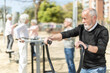 © JackF - Elderly men and women people keep fit and wellness, exercise outdoors, and use outdoor exercise equipment public sports ground.