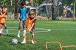 © chokniti - World cup concept with soccer ball or football player, young child soccer practice on field with training cone and ball