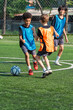 © chokniti - World cup concept with soccer ball or football player, youth soccer players compete on outdoor field in bright training bibs during active match