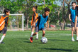 © chokniti - World cup concept with soccer ball or football player, youth soccer players on field in outdoor game under sunny sky