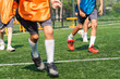 © chokniti - World cup concept with soccer ball or football player, soccer player training on green field with orange vest and red shoe in sunny outdoor practice
