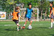 © chokniti - World cup concept with soccer ball or football player, youth soccer practice on green field with children in training vests playing ball