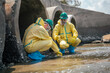 © Wanwajee - Scientists in hazardous material protection suits conduct wastewater testing near concrete drainage tunnels. Industrial pollution monitoring and improve water quality management.