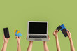 © Pixel-Shot - Female hands with credit cards, gadgets and payment terminal on green background. Online banking concept