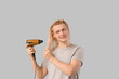 © Pixel-Shot - Young blonde man drying wet hair on light background