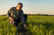 © Home-stock - Male farmer with digital tablet kneeling in wheat field, touching crop shoots
