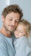 © Мария Фадеева - Adoptive father embracing sleeping child wrapped in a soft blue sweater for family bonding background and parenting campaign