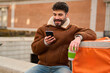 © Oscar - Delivery man checking phone during work break