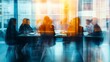 © Harry - A group of business professionals sitting around a conference table in a modern office with a blurred effect