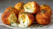© AndyAziz - Cheesy mozzarella stuffed potato balls with crispy golden brown crust and gooey melted cheese inside served on a white plate