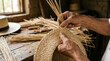 © hilwanstock - Hands Weaving a Traditional Panama Hat with Straw Fibers.