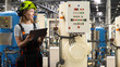 © Grispb - Water treatment plant, female technician checks control panel and industrial filtration equipment using tablet in processing facility.