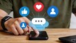 © Chloe - Hand Touching Smartphone With Floating Social Media Icons, Engagement Metrics Like Likes Hearts Comments, Mobile App Interaction And User Connection
