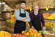 © JackF - Portrait of two male salesperson wearing an apron in the vegetable department of a supermarket