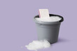 © Pixel-Shot - Plastic bucket of foam with sponge on purple background