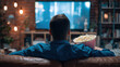© timurlan999 - Man relaxing watching television at home with popcorn
