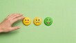 © olga_demina - This represents emotional assessment and risk management, with a hand reaching for a neutral emoticon among various facial expressions on a green background, symbolizing the importance of