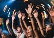 © Yuiziee - Excited Audience Cheering at Live Concert Event: Ultra realistic close up action shot of excited audience cheering at live music concert, hands raised, expressive faces, dramatic stage lighting