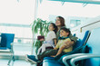 © SISMIZ - Family smiling and looking up while waiting at airport terminal