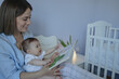 © SISMIZ - Mother reading storybook to baby in nursery