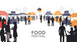© Adilah_Fathir - Silhouettes of people at a vibrant outdoor food festival market stalls.