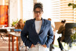 © Maria Vitkovska - Confident businesswoman wearing eyeglasses standing in modern office