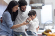 © .shock - Middle Eastern family sharing iftar and milk with young child at modern home kitchen during Ramadan Eid