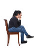© Curto - side  view of a woman sitting in a chair hand on chin and cross legged on a white background