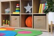 © New Africa - Shelving unit with toys, books and decor in child's room, closeup