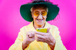 © oneinchpunch - Funny grandmother portraits. Senior old woman, interacting with a smartphone. Concept about seniority