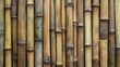 © Kalyca. - Close-up of a wall made of vertical bamboo stalks, showing variations in color and texture.