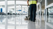 © unding - Professional cleaner using floor scrubber machine in empty terminal
