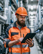 © Visual Studio - Industrial Engineer in Safety Helmet Using Digital Tablet for Machinery Monitoring at Manufacturing Plant